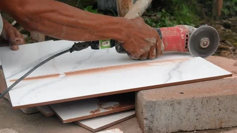 Male construction worker cutting ceramic tiles using grinder Stock Footage 307557506