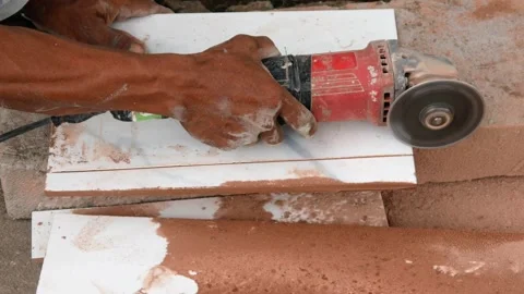 Male construction worker cutting ceramic tiles using grinder Stock Footage 307557509