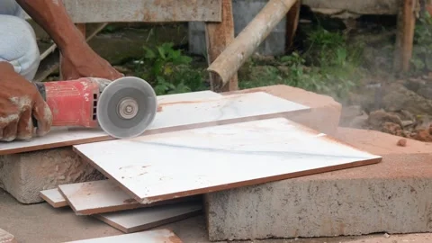 Male construction worker cutting ceramic tiles using grinder Stock Footage 307557514