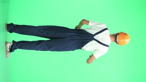 A male construction worker, on a green background, in full height, shows a stop Stock Footage 263656412