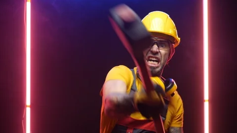A male construction worker in a hard hat hits with a sledgehammer Stock Footage 125926253