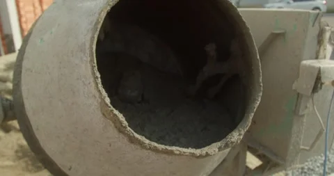 Male construction worker making concrete mix using cement mixer spinning slow Stock Footage 306152345