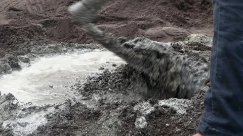A male construction worker is mixing sand and cement using a hoe Stock Footage 307003373