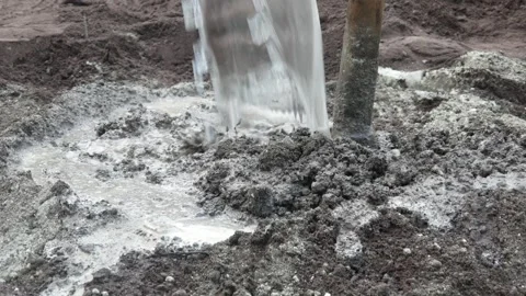 A male construction worker is mixing sand and cement using a hoe Stock Footage 307003427