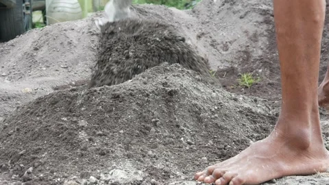 A male construction worker is mixing sand and cement using a hoe Stock Footage 307036622