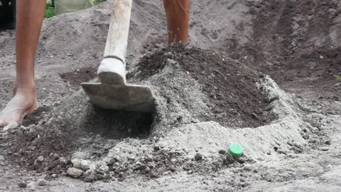 A male construction worker is mixing sand and cement using a hoe Stock Footage 307036658