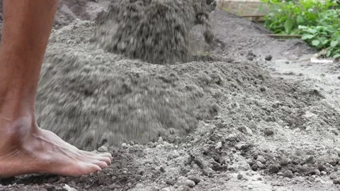 A male construction worker is mixing sand and cement using a hoe Stock Footage 307036764