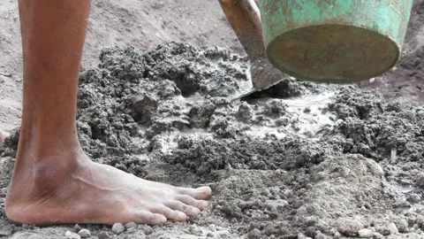A male construction worker is mixing sand and cement using a hoe Stock Footage 307038575