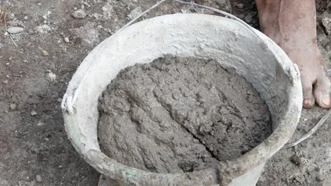 A male construction worker is mixing sand and cement using a hoe Stock Footage 307038596