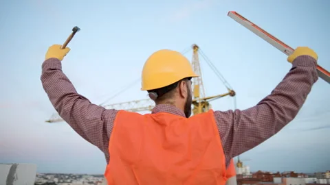 Male construction worker in slow motion celebrates achievement at building site Stock-Footage 295961001