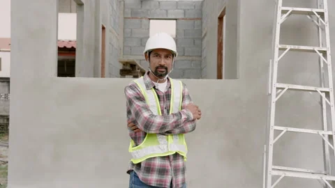 Male construction worker standing in front unfinished cement building Stock Footage 265252767