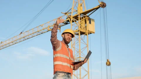 Male construction worker using laptop to analyze plans at building site Stock-Footage 295958628