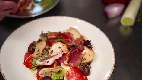 Male cook adding bacon prosciutto to make perfect presentation of healthy Stock Footage 106977498