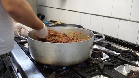 A male cook adding tomatoes in the meat sauce, 4K Stock Footage 72280878