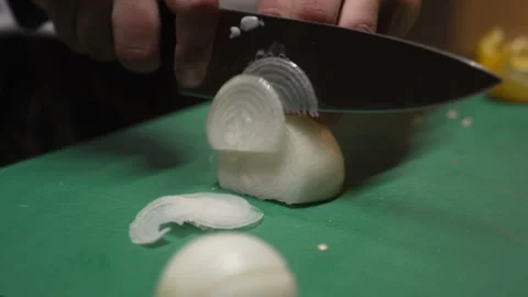Male cook's hands using a sharp knife to thinly slice fresh white onion Stock Footage 333580001