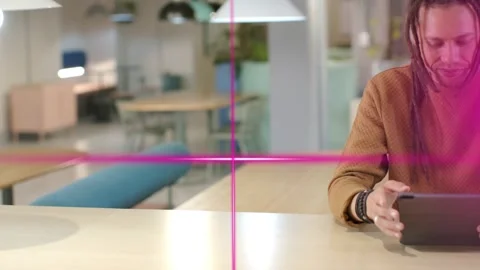 Male creative sitting at tech table, tapping tablet and testing app, magenta Stock Footage 329959745