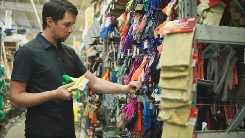 Male customer in the hardware store choosing garden gloves. Stock Footage
