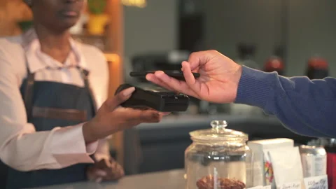 Male customer paying for purchase using smartphone in modern cafe shop spbas. Stock Footage 158916486