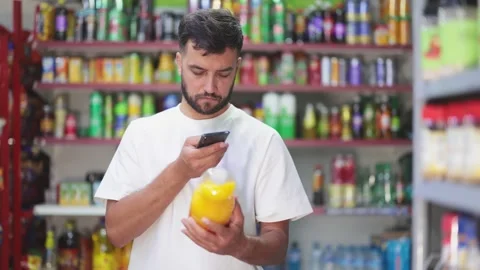 Male customer scans barcode code on soft drinks in grocery store Stock Footage 341426176
