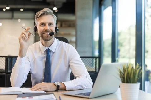 Male customer support operator with headset and smiling. Stock Photos