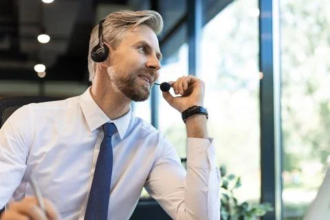 Male customer support operator with headset and smiling. Stock Photos