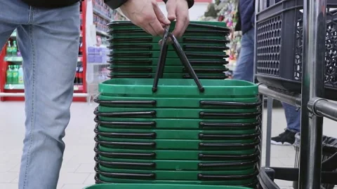 Male customer takes empty plastic hand baskets from stack  in store. Stock Footage