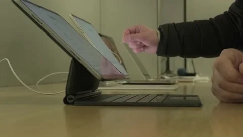 Male customer testing new tablet in apple sales office in Germany, products.. Stock Footage 224897129