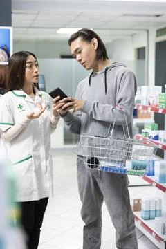 Male Customer Using Cellphone During Pharmacy Consultation Stock Photos