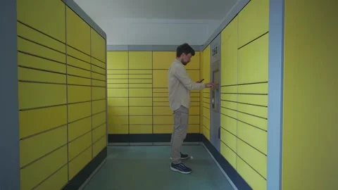 Male customer using self-service automated delivery terminal to send package or Stock Footage 242792164