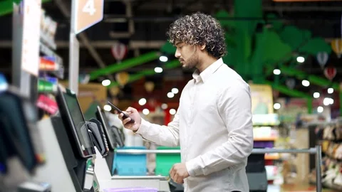 Male customer using self-service cashier checkout in a supermarket Shopper scann Stock Footage 292914770