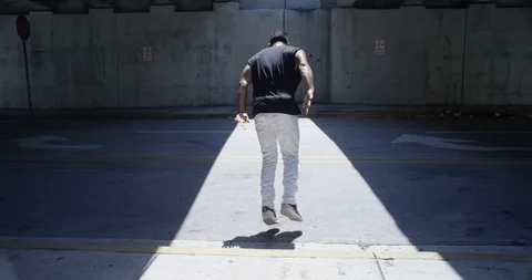 Male dancer performing flips under an overpass Stock Footage 97035990