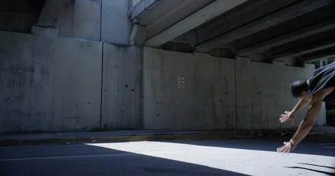 Male dancer performing flips under an overpass Stock Footage 97037009