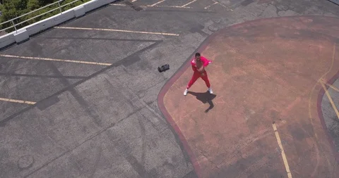 Male dancer performing his routine on top of a parking garage Vídeos de archivo 97014434