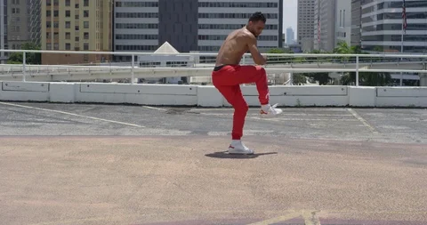Male dancer performing his routine on top of a parking garage Stock Footage 97034788