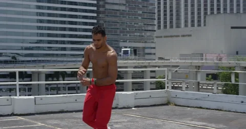 Male dancer performing his routine on top of a parking garage Stock Footage 97240474