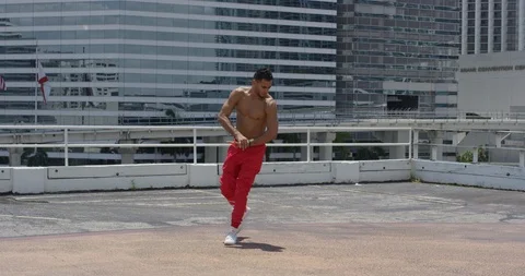 Male dancer performing his routine on top of a parking garage Stock Footage 97251380