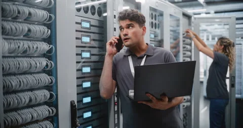 Male Data Center Engineer Reporting Server Performance by Smartphone Stock Footage 344964602