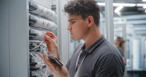 Male Data Center Technician Verifying Ethernet Cabling While Female Colleague Stockbeeldmateriaal 344977948