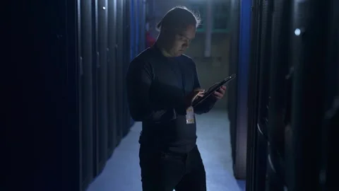 Male data engineer working with device and inspecting server equipment in data Stock Footage 163816458