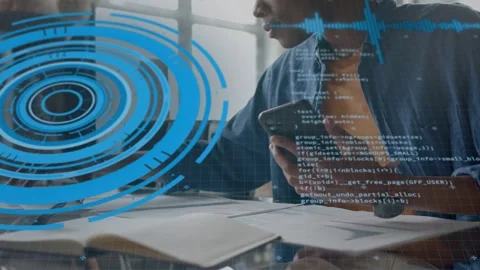 Male dev grabbing phone reaching desk referencing docs while HUD and code Stock Footage 334338148