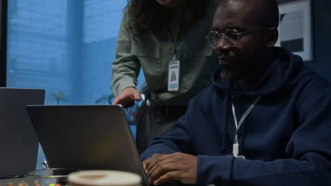 Male Developer Coding on Laptop and Listening to Advice of Long-Haired Guy Stock Footage 329615783