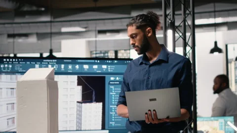 Male developer evaluating architectural 3D models and plans Stock Footage 316646246