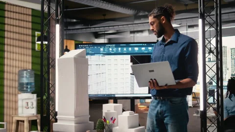 Male developer evaluating architectural 3D models and plans Video stock 316796138