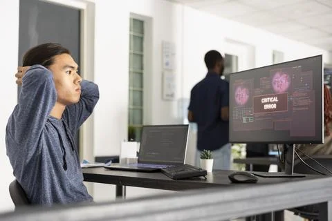 Male developer experiencing critical software error on computer Stockfoto's