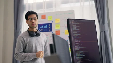 A male developer gestures towards a strategy outlined on a whiteboard. Stock Footage 310589223