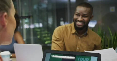 Male developer gesturing with paper, presenting code overlay via laptop during Stock Footage 330379476
