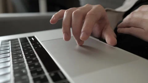 Male developer hands scroll and swipe on laptop touchpad looking on display in Stock Footage 255209639