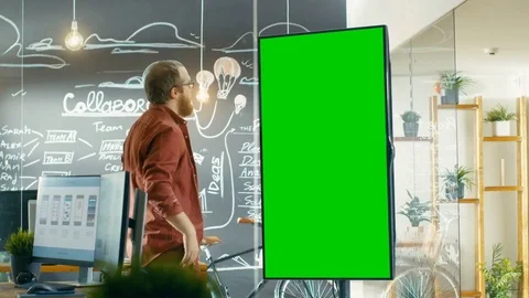 Male Developer Looks at Interactive Whiteboard with Mock-up Green Screen.  Stock Footage 82889301