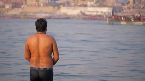 A male devotee is praying and taking a holy bath in the river Ganges Stock Footage 320454197