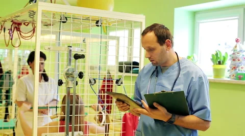 Male doctor comparing data on tablet computer in rehabilitation room HD Stock Footage 45580186